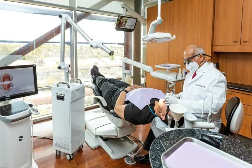 Dentist performing dental procedure on patient in chair