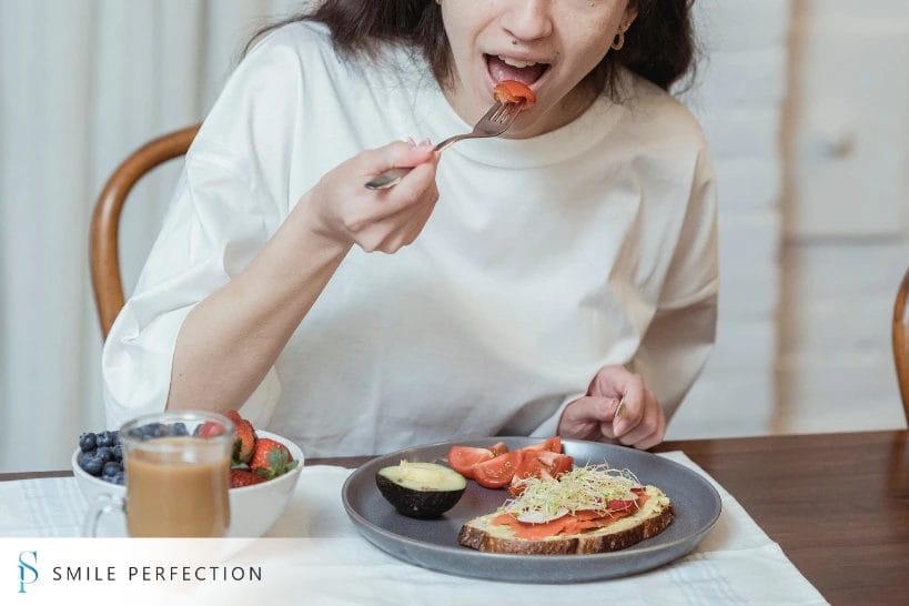 Woman eating healthy foods suitable for dental bridge care